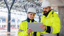 Engineers using a tablet on a construction site