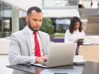 Man using laptop and woman using tablet